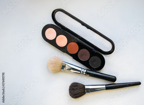Professional makeup eyeshadow palette closeup. Makeup brushes. Flatlay. White background.
