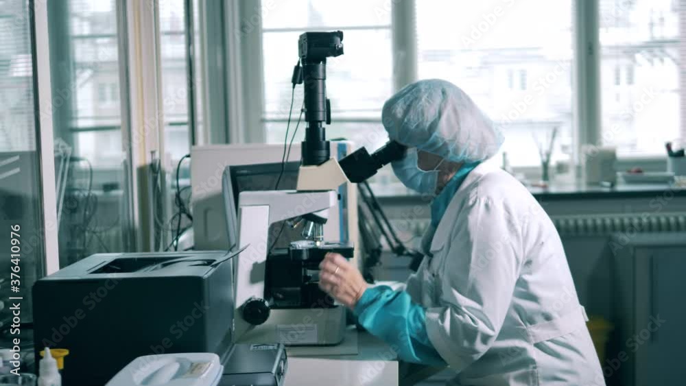 Female chemist is researching medicine under a microscope Female chemist is researching medicine under a microscope