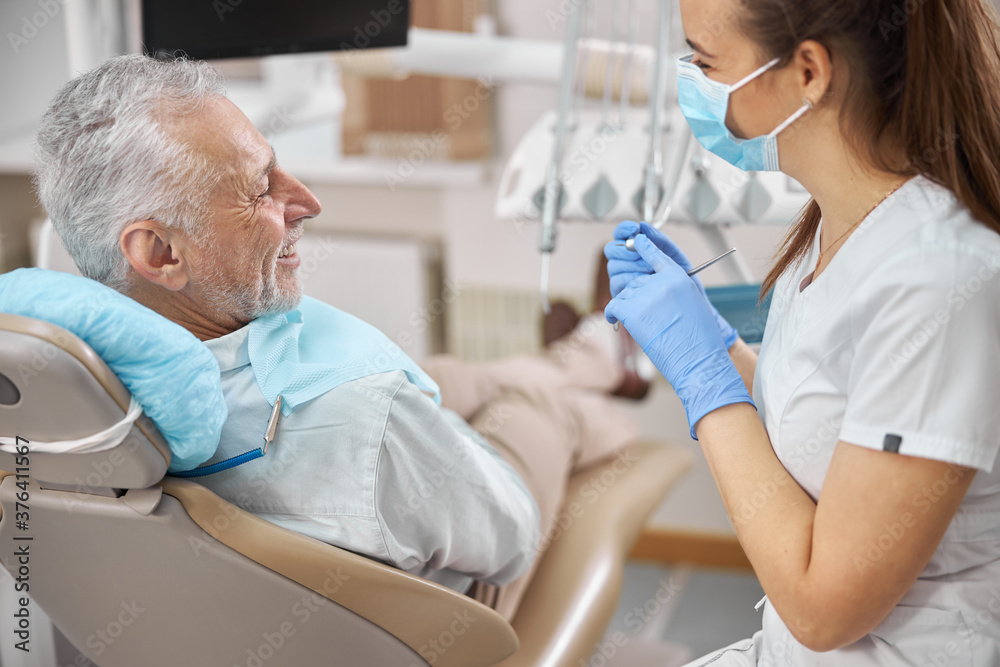 Fototapeta premium Positive-looking elderly man having a dental appointment