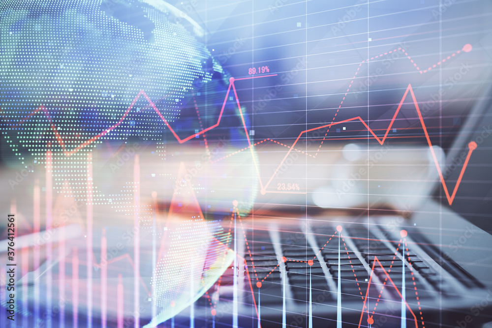 Financial graph colorful drawing and table with computer on background. Double exposure. Concept of international markets. Financial graph colorful drawing and table with computer on background. Double exposure. Concept of international markets.
