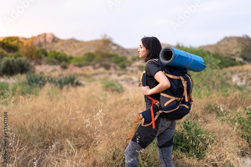 Young mountaineer girl with a big backpack at outdoors