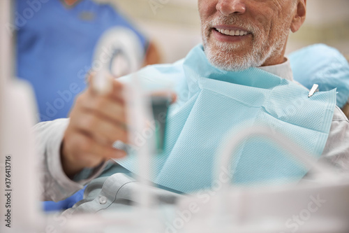 Fotografija Senior patient having a cup with a mouthwash to rinse his mouth