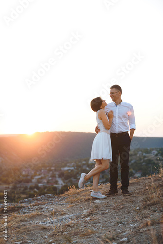 hugging couple on sunset hill