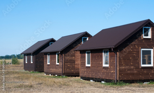 Wooden houses. Brown. Against the background of the sky and steppe © amdre100