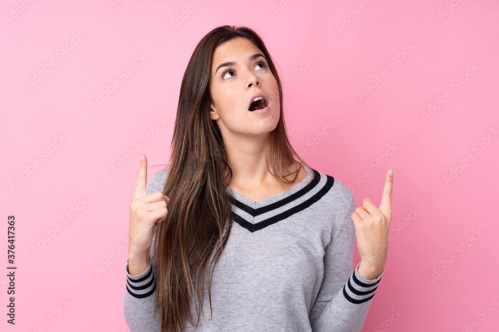 Teenager girl over isolated pink background pointing with the index finger a great idea Teenager girl over isolated pink background pointing with the index finger a great idea