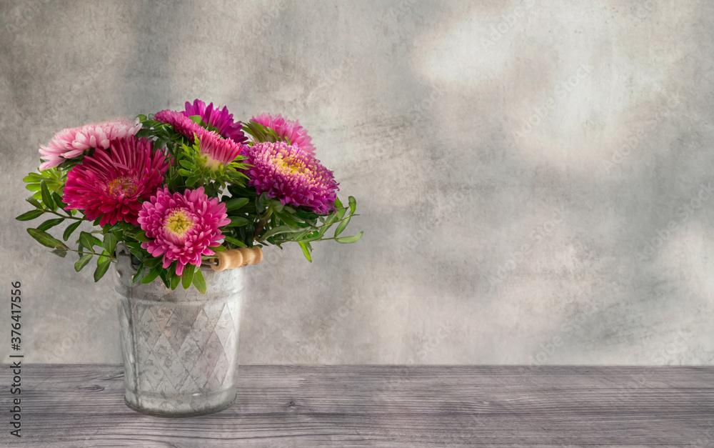 pink leuchtende blumen im topf dekoration auf rustikalem holztisch vor alter verwischter wand pink leuchtende blumen im topf dekoration auf rustikalem holztisch vor alter verwischter wand