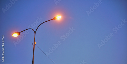 Street lamp silhouette from low angle during dawn.