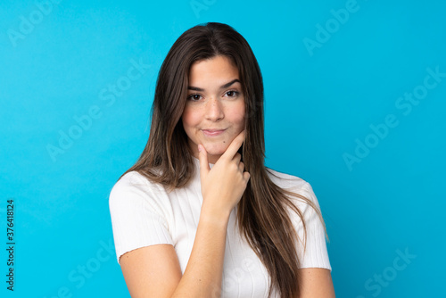 Teenager girl over isolated blue background thinking