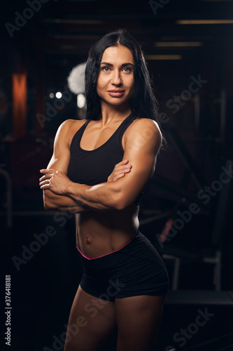 Beautiful fit brunette lady posing at the gym