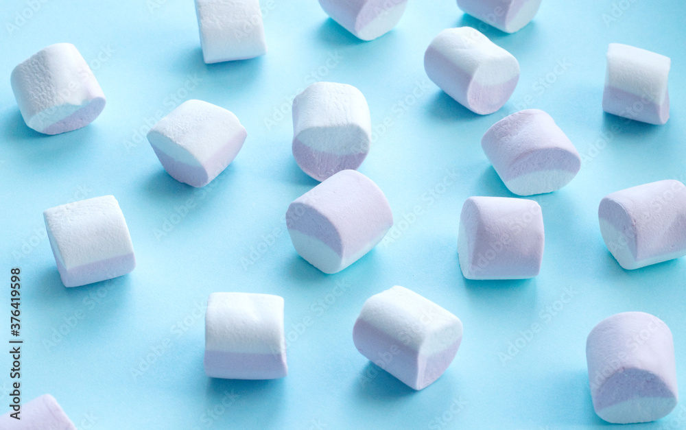 scattering of marshmallows, multi-colored candies, marshmallows, on a flat blue surface. Reflection of the shadow. Sweet life, sugar problems, joy for children, addiction. Holiday sweets, sweet decor, scattering of marshmallows, multi-colored candies, marshmallows, on a flat blue surface. Reflection of the shadow. Sweet life, sugar problems, joy for children, addiction. Holiday sweets, sweet decor,