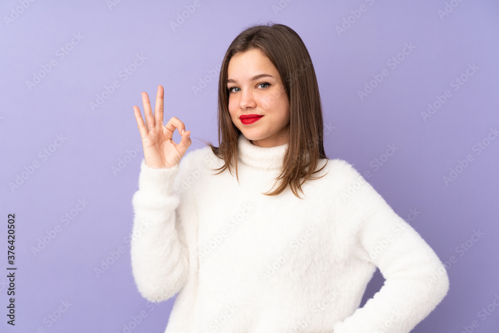 Teenager girl isolated on purple background showing ok sign with fingers Teenager girl isolated on purple background showing ok sign with fingers