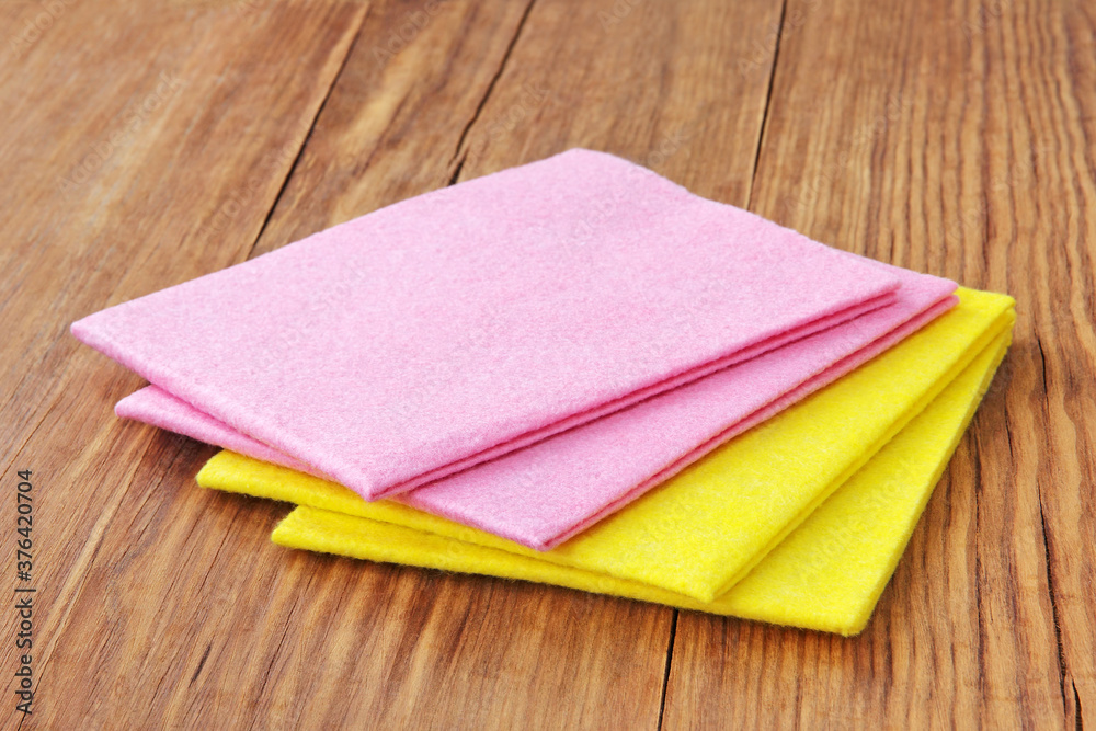 Fototapeta premium Multicolored micro fiber napkins on wooden background.