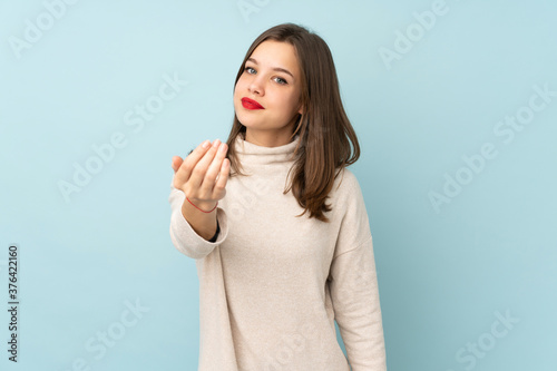 Teenager girl isolated on blue background inviting to come