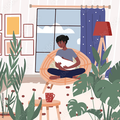 Mother breast feeding her newborn baby in lotus pose, yoga, meditation. Woman breastfeeding infant indoors. Trendy scandinavian hygge interior, living room. Happy motherhood, natural feeding concept