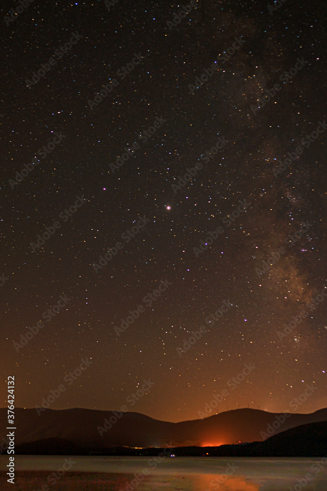 Obraz premium The amazing sky view of Milky Way from Bafa lake is a peaceful place, ringed by traditional villages such as Kapıkırı full of fisherman boats and ruins of Herakleia