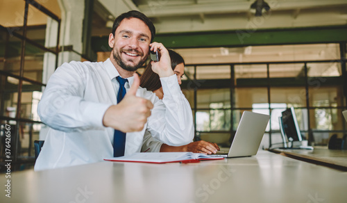 Portrait of cheerful executive manager communicating with business partner connecting to 4g internet on modern smartphone technology, cheerful male employee smiling at camera during phone talk