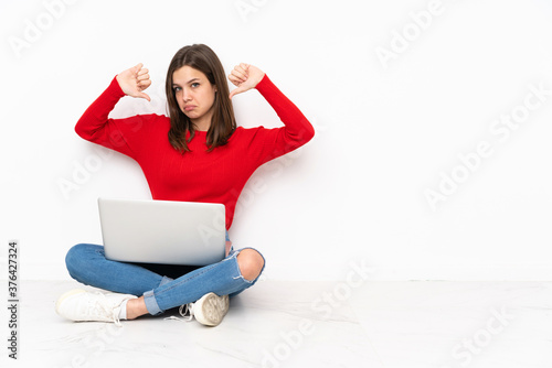 Tenaager girl working with pc isolated on white background showing thumb down