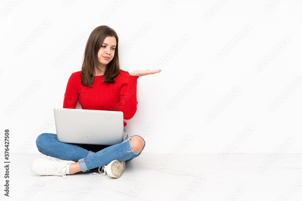 Tenaager girl working with pc isolated on white background holding copyspace with doubts Tenaager girl working with pc isolated on white background holding copyspace with doubts