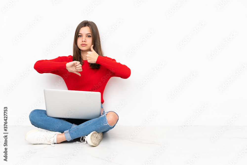 Tenaager girl working with pc isolated on white background making good-bad sign. Undecided between yes or not Tenaager girl working with pc isolated on white background making good-bad sign. Undecided between yes or not