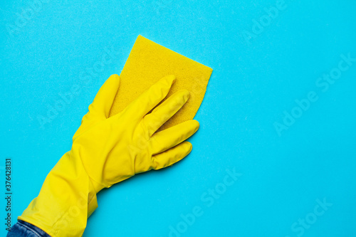 Close up of a woman in yellow mittens holding a cleaning rag