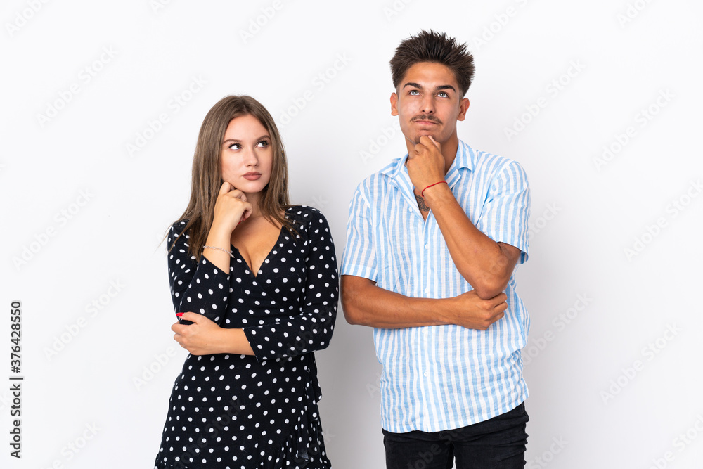 Young caucasian couple isolated on white background standing and thinking an idea