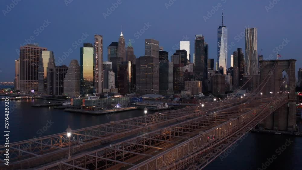 early dawn view of NYC skyline flying backward alongside Brooklyn Bridge early dawn view of NYC skyline flying backward alongside Brooklyn Bridge