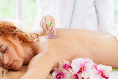 Beautiful woman relaxing in spa salon with vacuum body massage