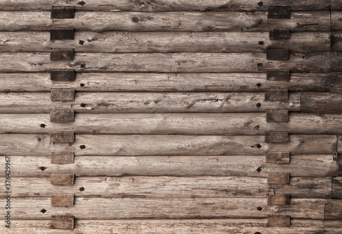 Old brown wooden wall made of rough logs. Texture