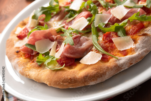 Deliziosa pizza con prosciutto crudo di Parma, rucola e scaglie di formaggio grana, Cucina Italiana