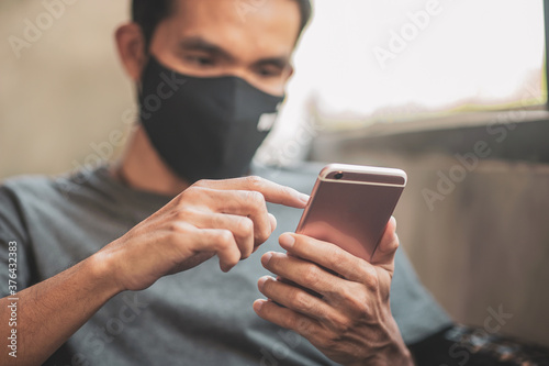 Man using mobile phone at home,Asian man holding phone in cafe
