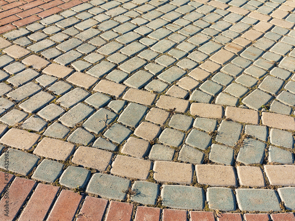 Sidewalk tile. Close-up paving slabs by mosaic. Road paving, construction. Colored concrete paving slab. Diagonal.