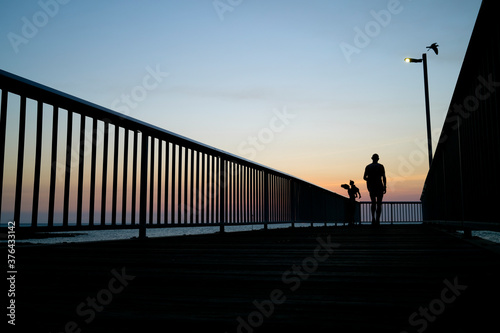 silhouette of a couple walking on the bridge