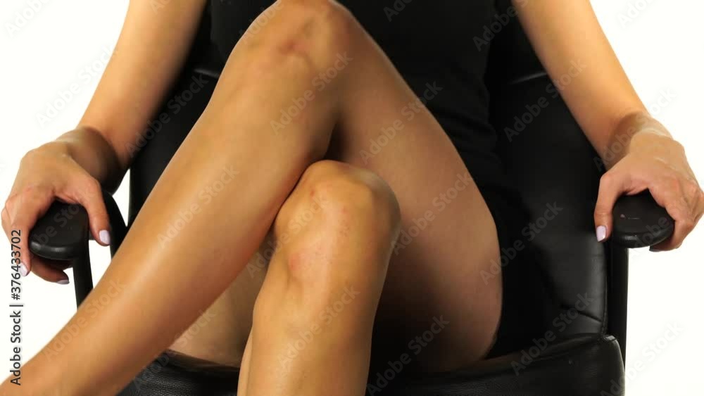 crossed female nude legs open and cross again on a black background