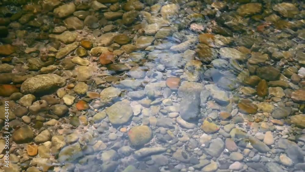 Transparent river in spain. Bedrock above a river. Round shaped stones Transparent river in spain. Bedrock above a river. Round shaped stones