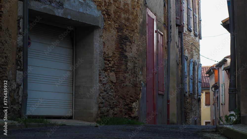 Petite ruelle de la ville d'Éauze, avec vue rapprochée sur diverses portes et volets colorés