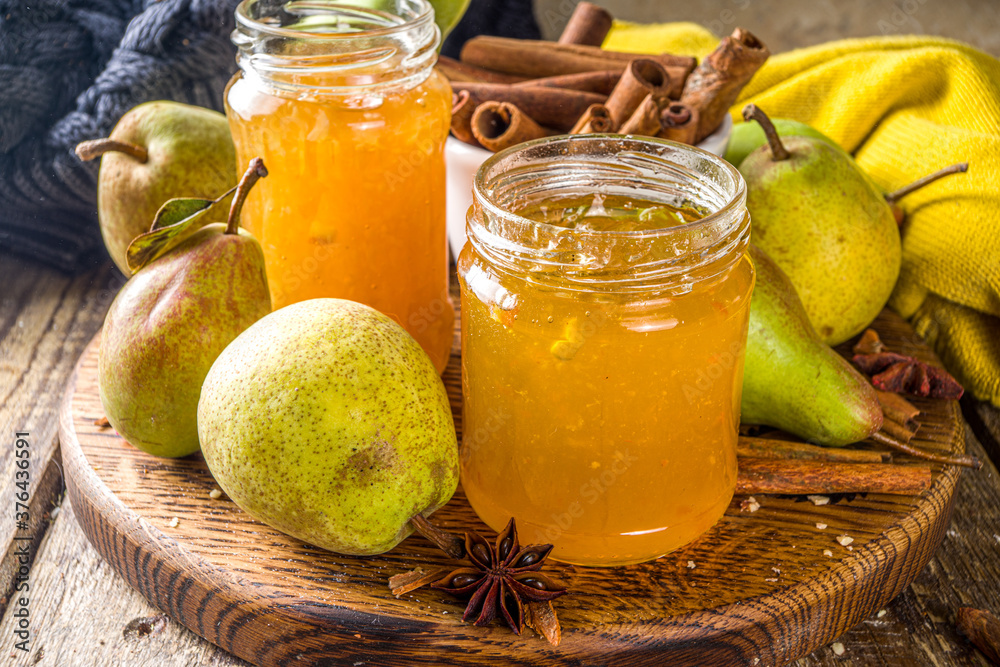 Homemade sweet and spicy pear jam. Different glass jars with pear jam, on wooden background with fresh pears and spices Homemade sweet and spicy pear jam. Different glass jars with pear jam, on wooden background with fresh pears and spices