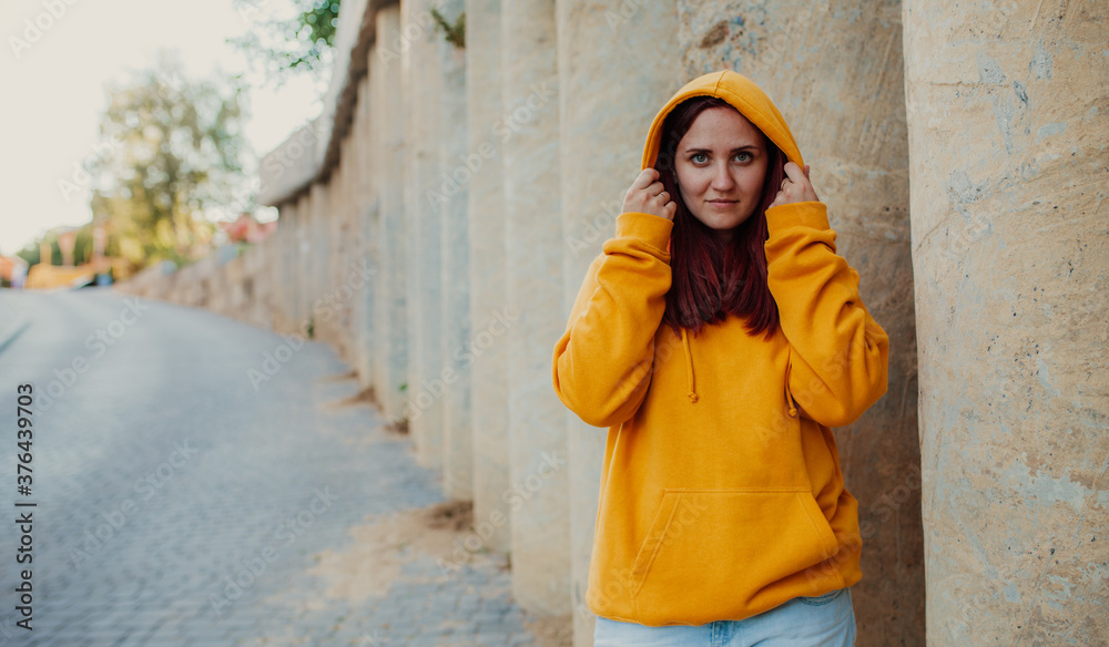 City portrait of handsome beautiful plus size girl wearing casual yellow blank hoodie or sweatshirt with space for your logo or design. Mockup for print City portrait of handsome beautiful plus size girl wearing casual yellow blank hoodie or sweatshirt with space for your logo or design. Mockup for print