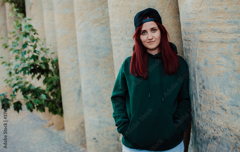 City portrait of handsome beautiful plus size girl wearing casual green (watercolor) blank hoodie or sweatshirt with space for your logo or design. Mockup for print