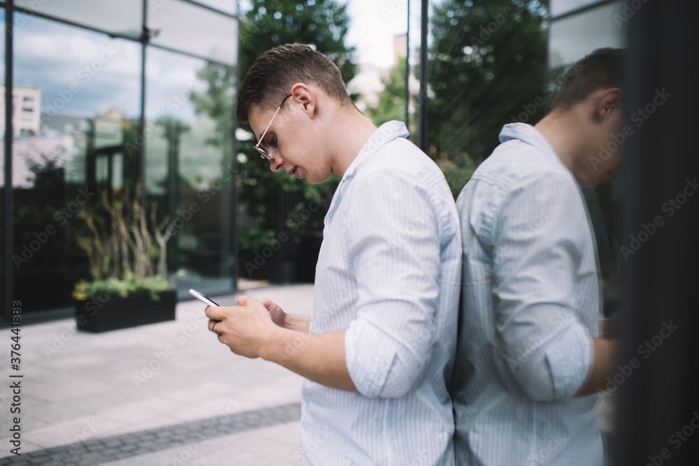 Focused male using smartphone in street Focused male using smartphone in street