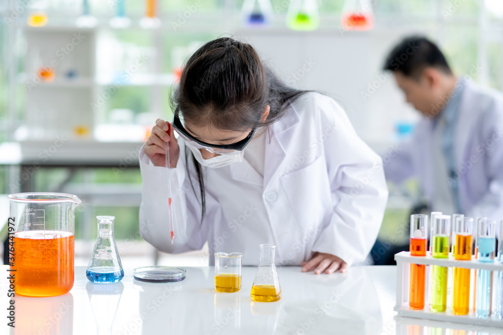 Lovely little girl enjoy to examine the color chemical in laboratory with day light. Concept of good practice and education of science for children support their learning. Lovely little girl enjoy to examine the color chemical in laboratory with day light. Concept of good practice and education of science for children support their learning.
