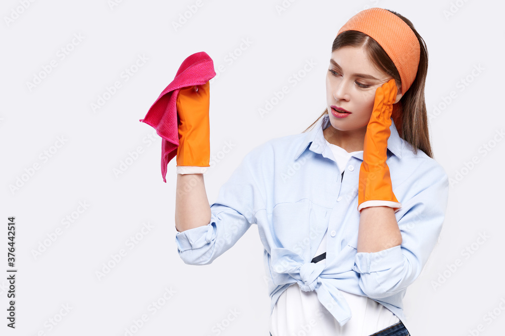 Tired woman with red rag and in protective gloves isolated on white background. Woman at work, professional maid cleaning. Cleaning or housekeeping concept Tired woman with red rag and in protective gloves isolated on white background. Woman at work, professional maid cleaning. Cleaning or housekeeping concept