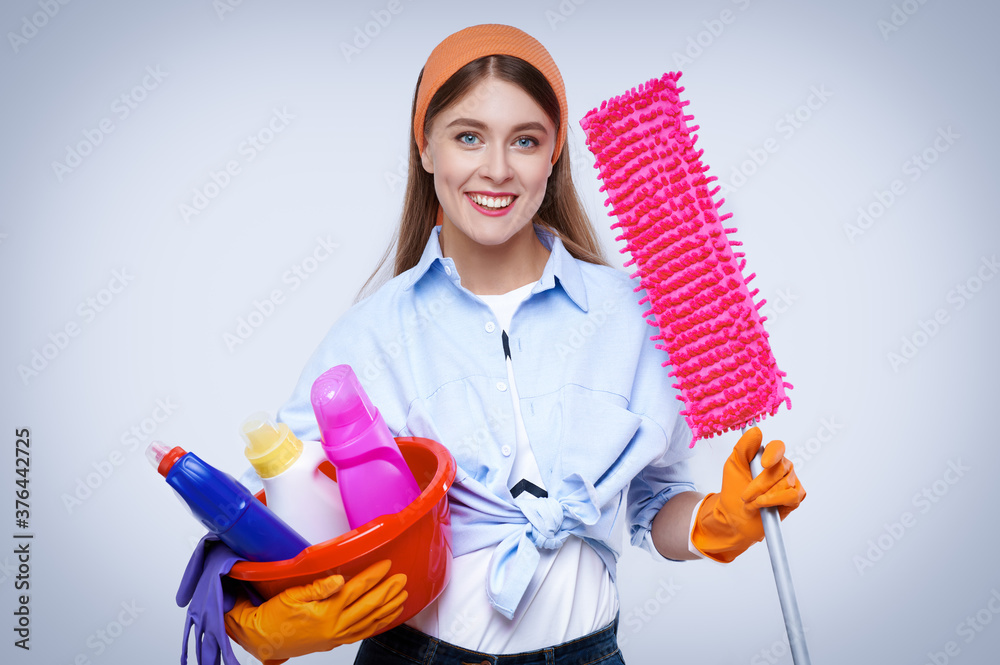 Woman with basin of cleaning supplies, lady with basket with detergents and brushes Woman with basin of cleaning supplies, lady with basket with detergents and brushes