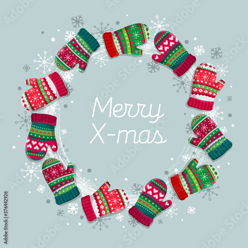 Decorative wreath with quote Merry Christmas on dark background. Traditional winter holidays home and door decoration. Mittens, Xmas night, snowflakes.