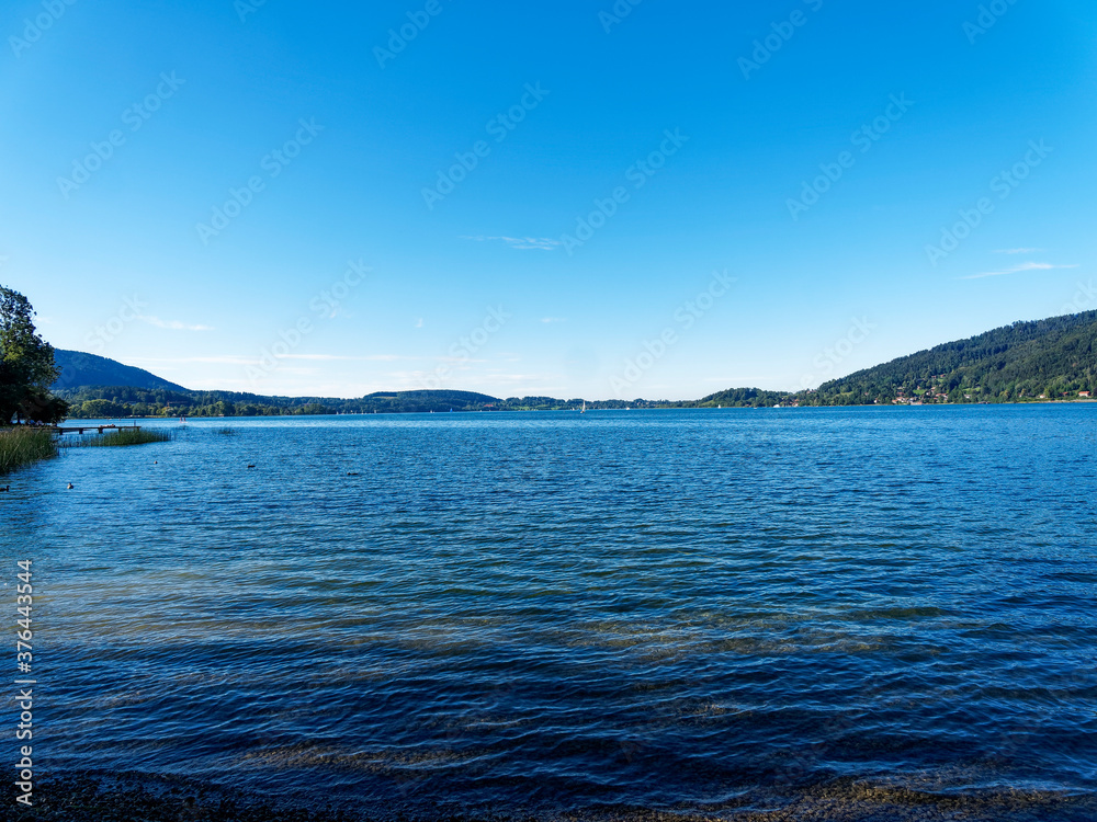Along the promenade on the beach of Bad Wiessee with view on the lake of Tegern and the shore of Gmund am Tegersee