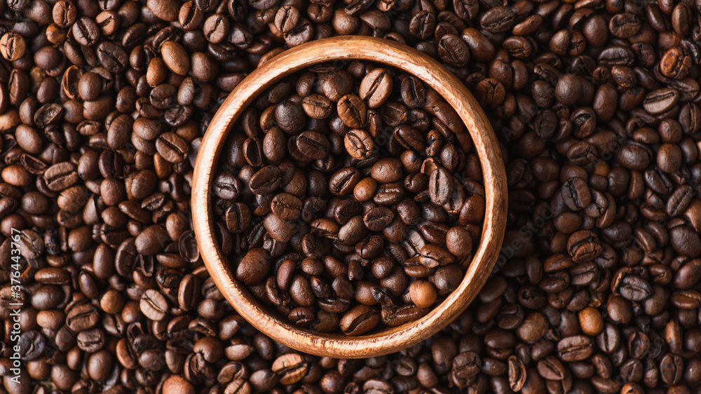 Fototapeta premium top view of coffee beans in wooden bowl