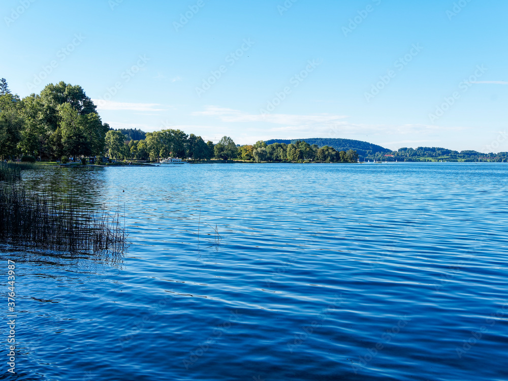 Along the promenade on the beach of Bad Wiessee in Upper Bavaria in Germany with view on the lake of Tegern and the shore of Gmund am Tegersee