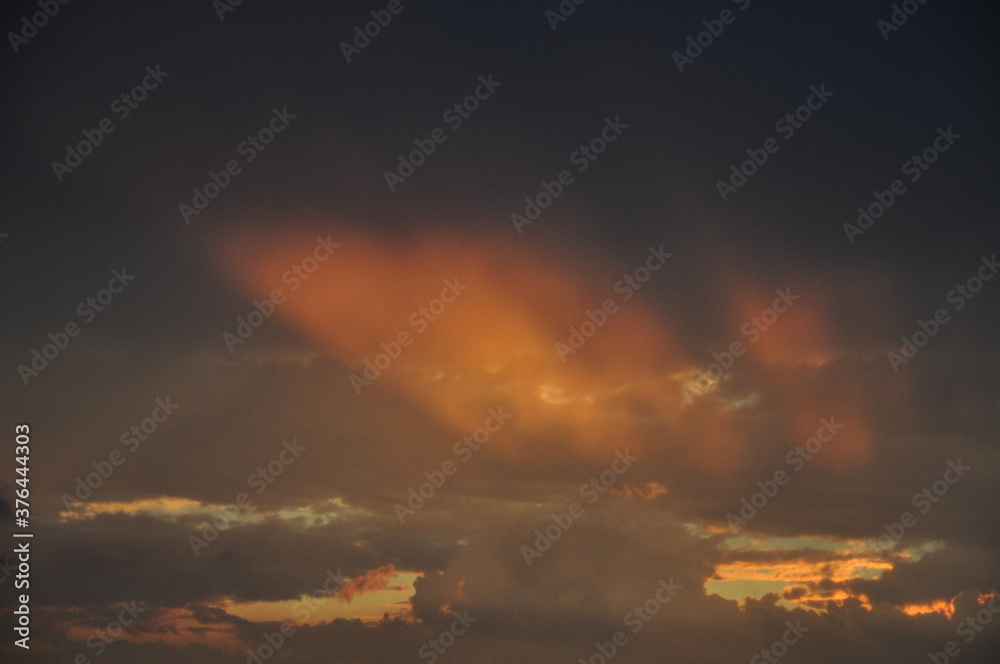 Fototapeta premium Heavenly Light Rays Through Orange Clouds