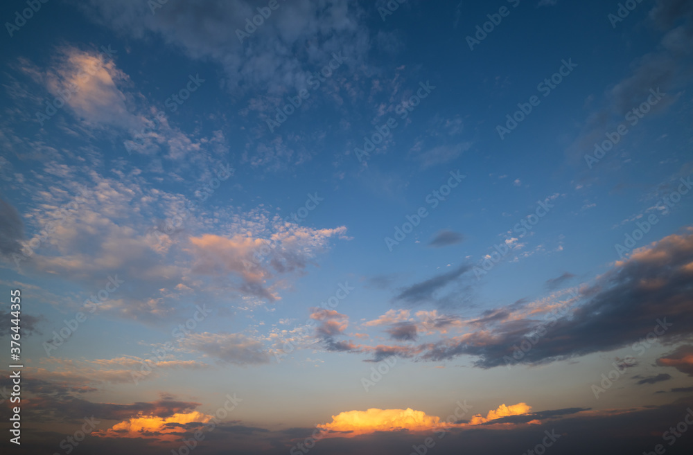 Summer sunset sky with fleece colorful clouds. Evening dusk good weather natural background.