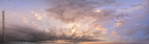 Fluffy clouds in evening overcast sky panoramic view. Climate, environment and weather concept sky background.