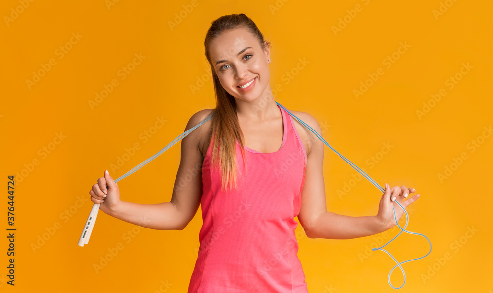 Positive Sporty Woman With Jump Rope Posing Over Yellow Background Positive Sporty Woman With Jump Rope Posing Over Yellow Background